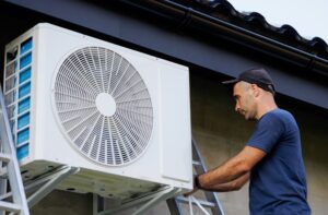 Technician servicing an outdoor air conditioning unit, emphasizing HVAC maintenance for home comfort in Woods Cross.