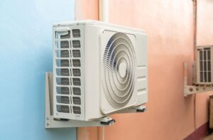 Air conditioning unit mounted on a wall, illustrating HVAC installation relevant to cooling solutions for homeowners in Woods Cross.