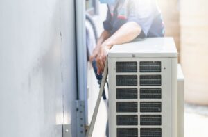 Technician performing maintenance on an air conditioning unit, emphasizing HVAC service and repair in Woods Cross.